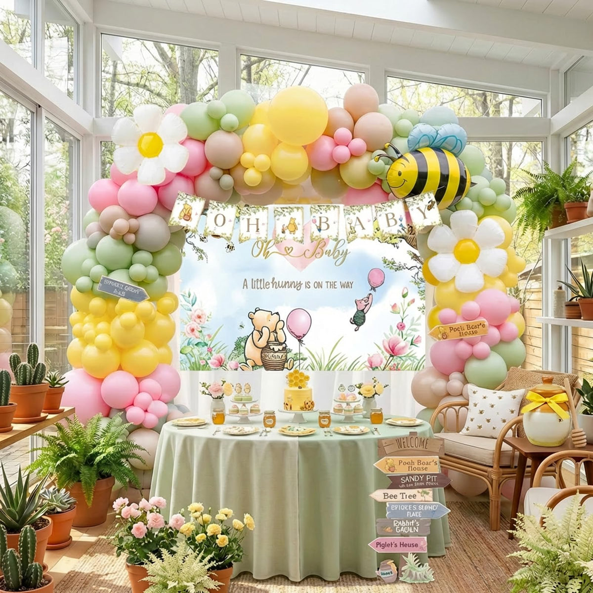 Kozee Winnie arch balloons with banner backdrop for a whimsical party setup.
