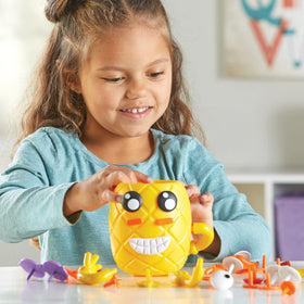 Crown-removal storage keeps pieces organized and ready for cleanup with Learning Resources Pineapple.