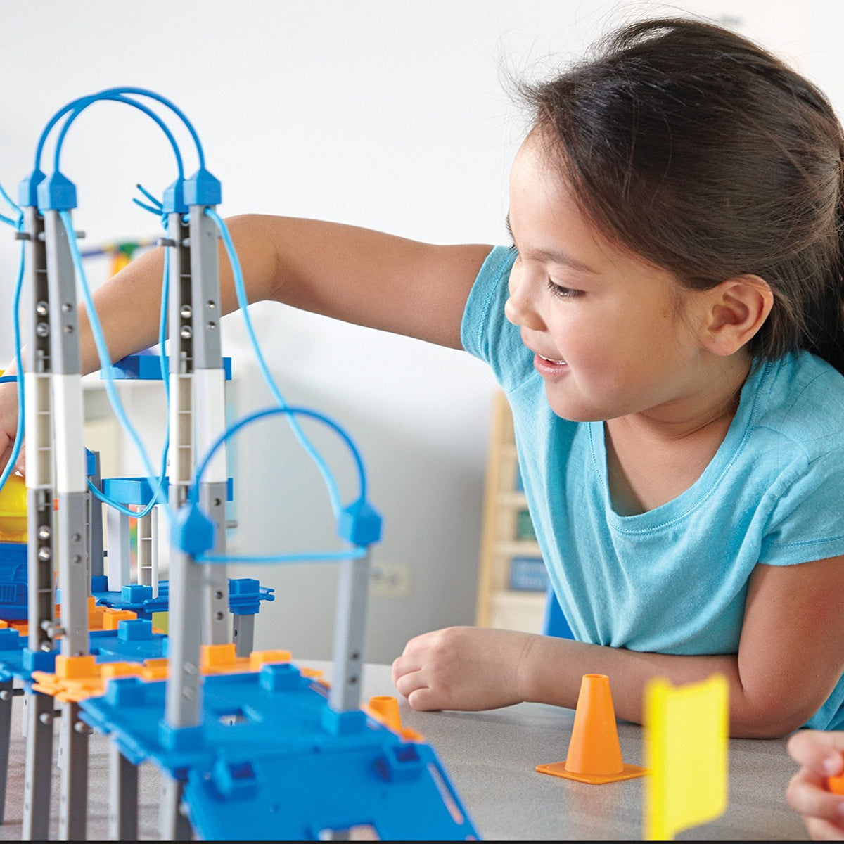 Crane and bridge models built with Learning Resources pieces demonstrate structural ideas in play.