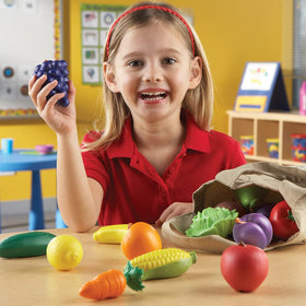 Close-up of red apple and carrot on Learning Resources tote for safe play