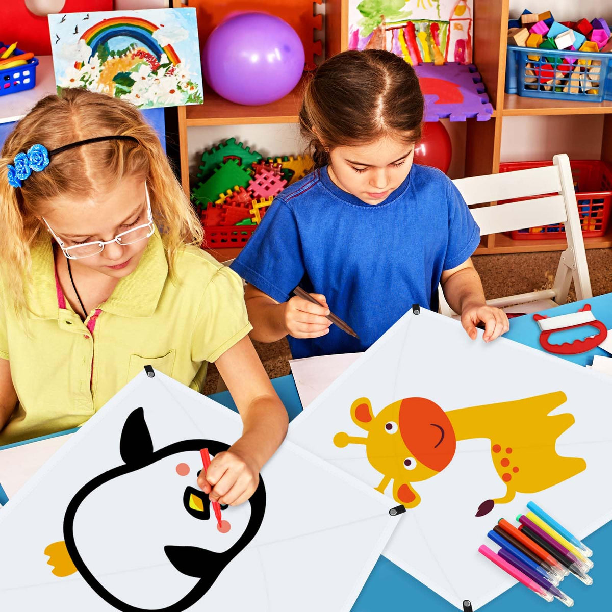 Libima children decorating a kite with colorful designs.