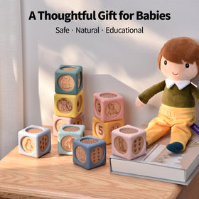 Little Rawr toddler grasping blocks with soft texture for safe handling.