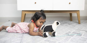 Lovevery The Pull Pup open-ended play on various surfaces like floors and rugs