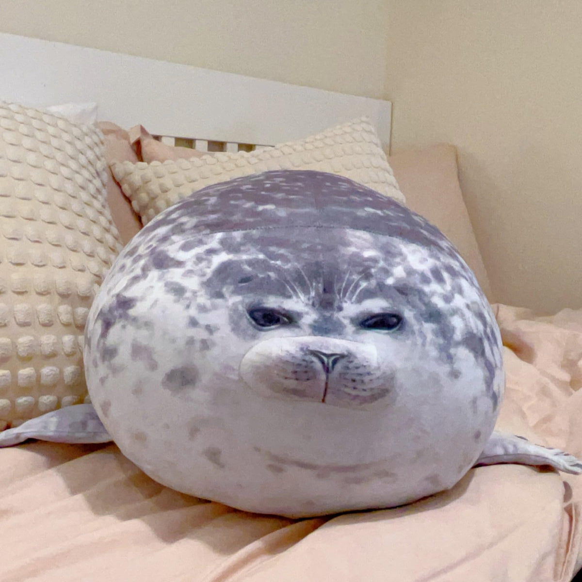 LUXSIT seal pillow on bed for large, comforting hugs.