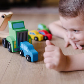 Kids enjoy a home play scene with this wooden car carrier.