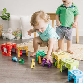 Garages stacked into a tower by Melissa & Doug for stacking skills.