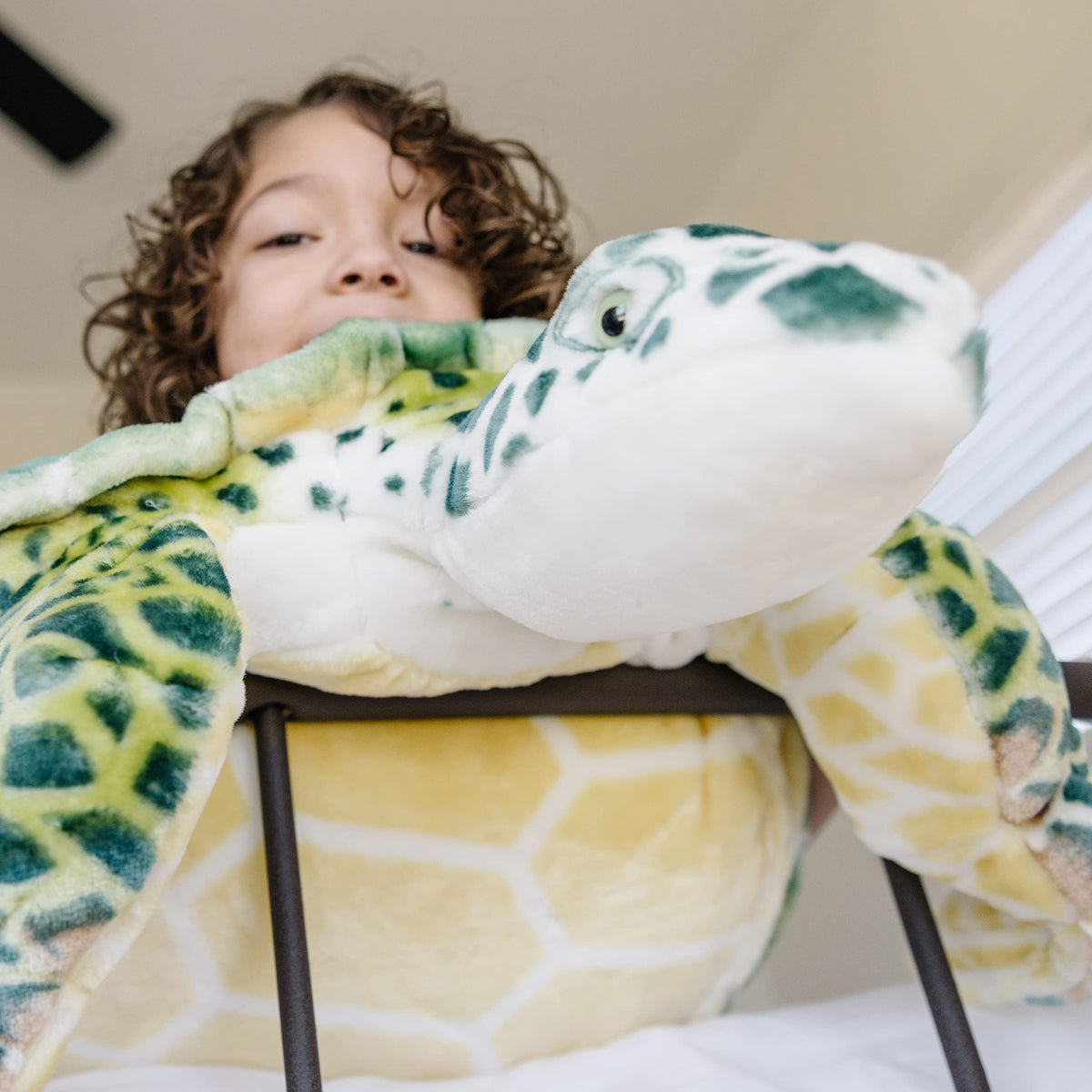 Sea turtle plush used as cozy room decor for play and stories.
