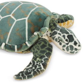 Melissa & Doug Giant Sea Turtle plush beside a child for size comparison.