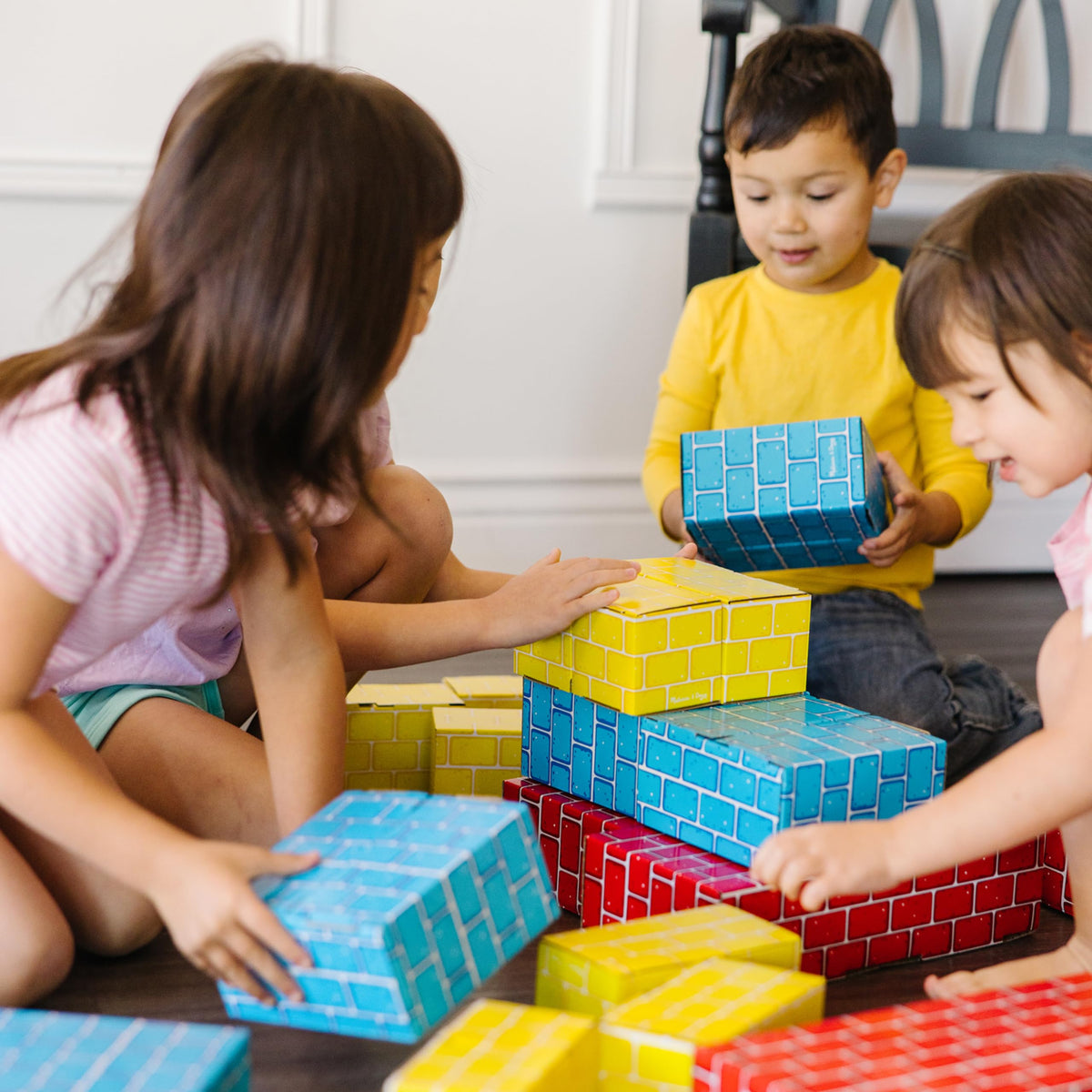 Kids building a tower with Melissa & Doug blocks fosters cooperation.