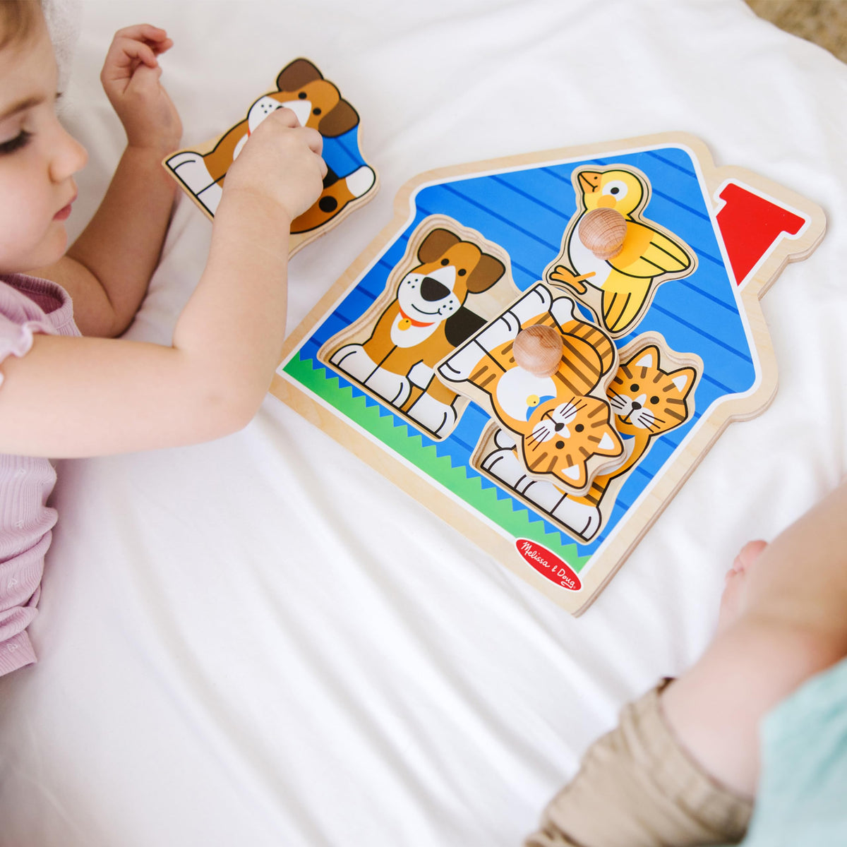 Melissa & Doug jumbo peg puzzles in small hands boost coordination.