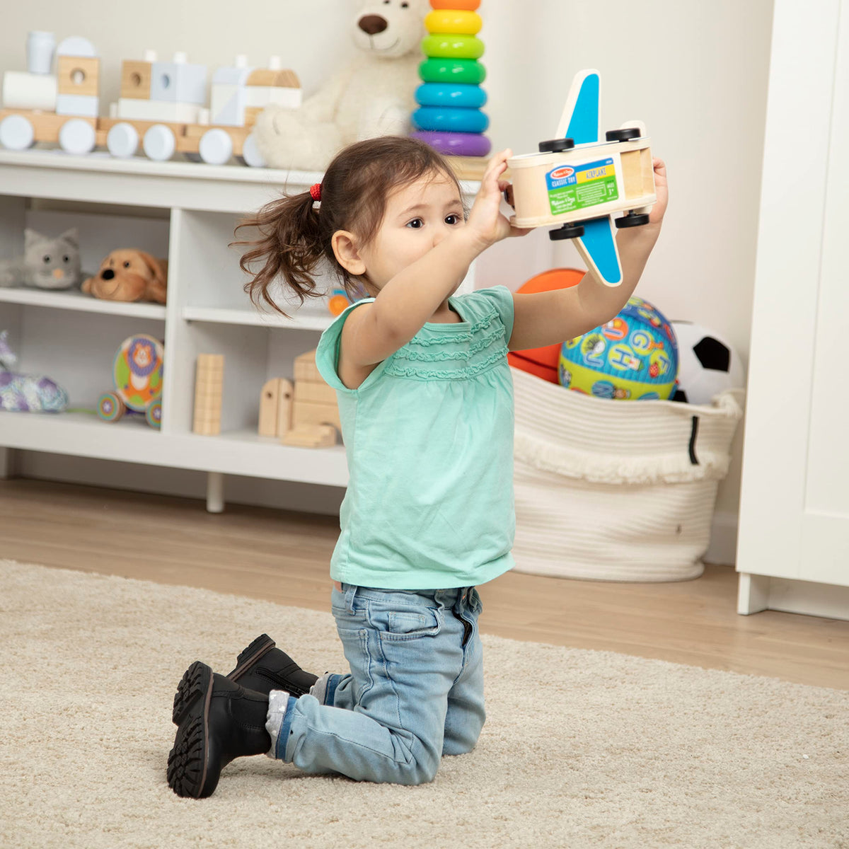 Kids enjoy open-ended play with a Melissa & Doug wooden airplane.