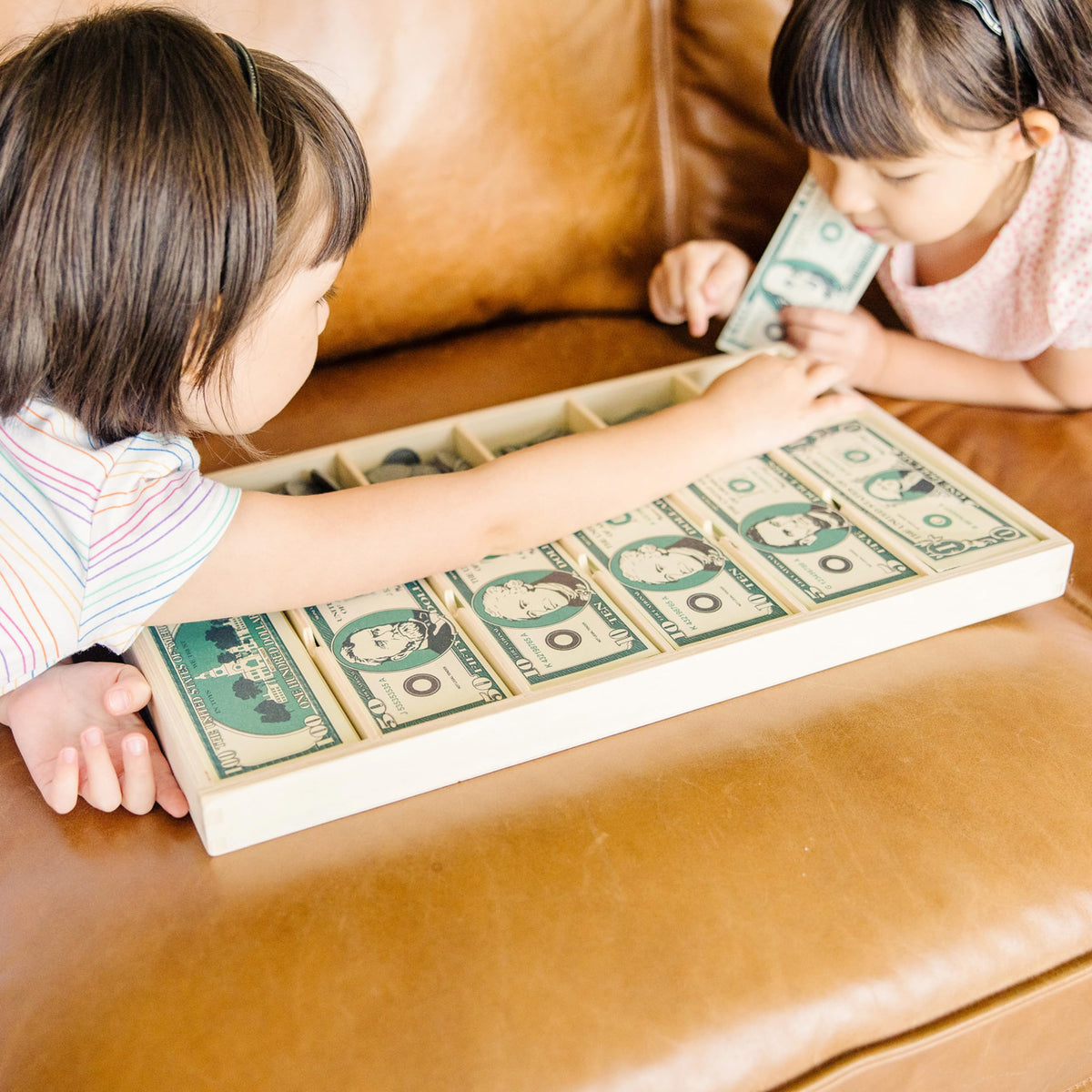 Melissa & Doug kids simulate store scenarios to boost imaginative play and math.
