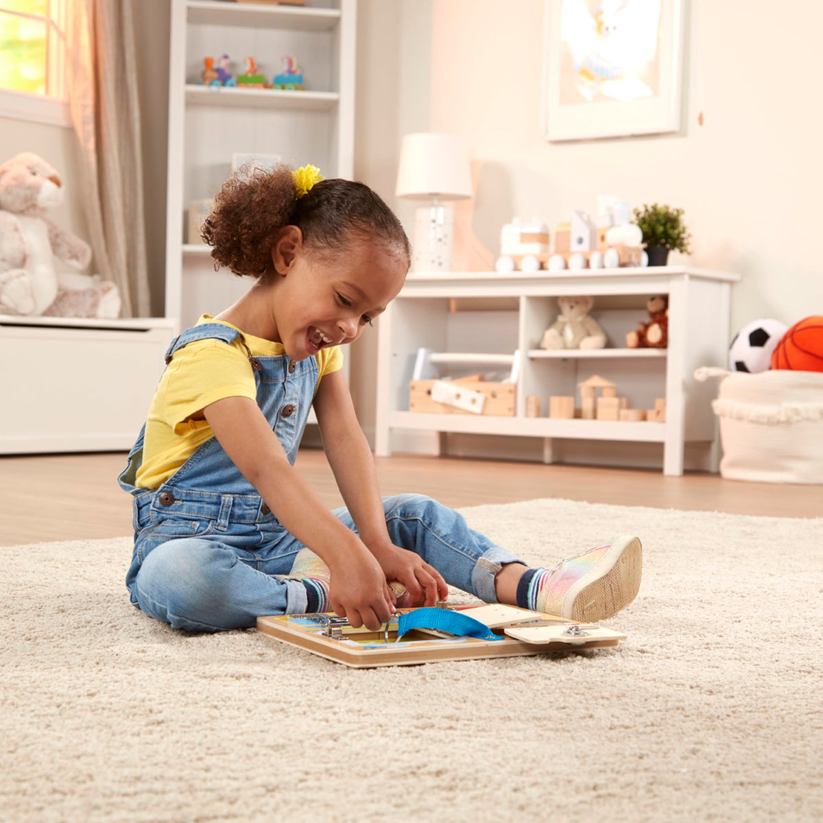 Close-up of locks and latches on Melissa and Doug board encouraging tactile exploration.