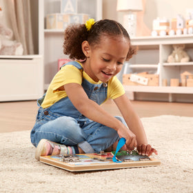 Colorful scenes under doors on the Melissa and Doug board invite storytelling and imagination.
