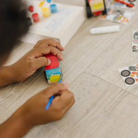 Paintbrush and paints included for creative customization in Melissa & Doug kit.