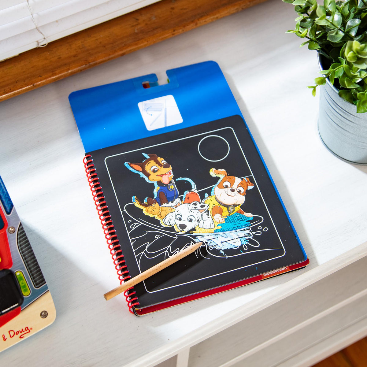 Chase scene from Paw Patrol Scratch Art pad reveals rainbow colors.