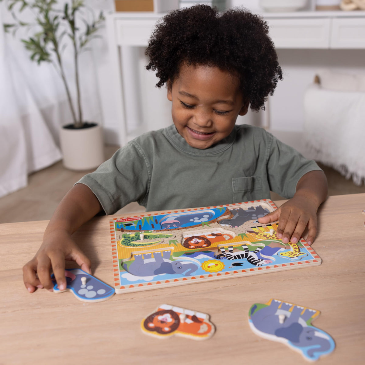 Child plays Melissa & Doug peg puzzles, exploring learning through hands-on activity