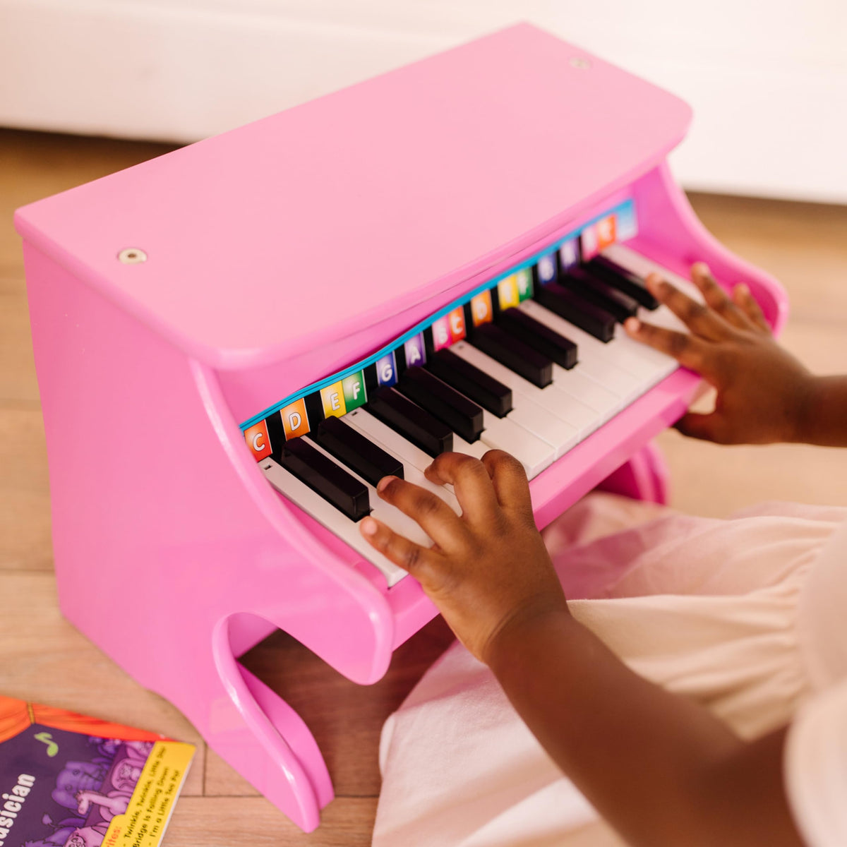 Melissa & Doug child enjoys screen-free play with the pink piano.