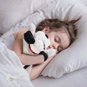 Meowtastic 22 inch weighted dog plush on a cozy bed, ideal for bedtime rituals.