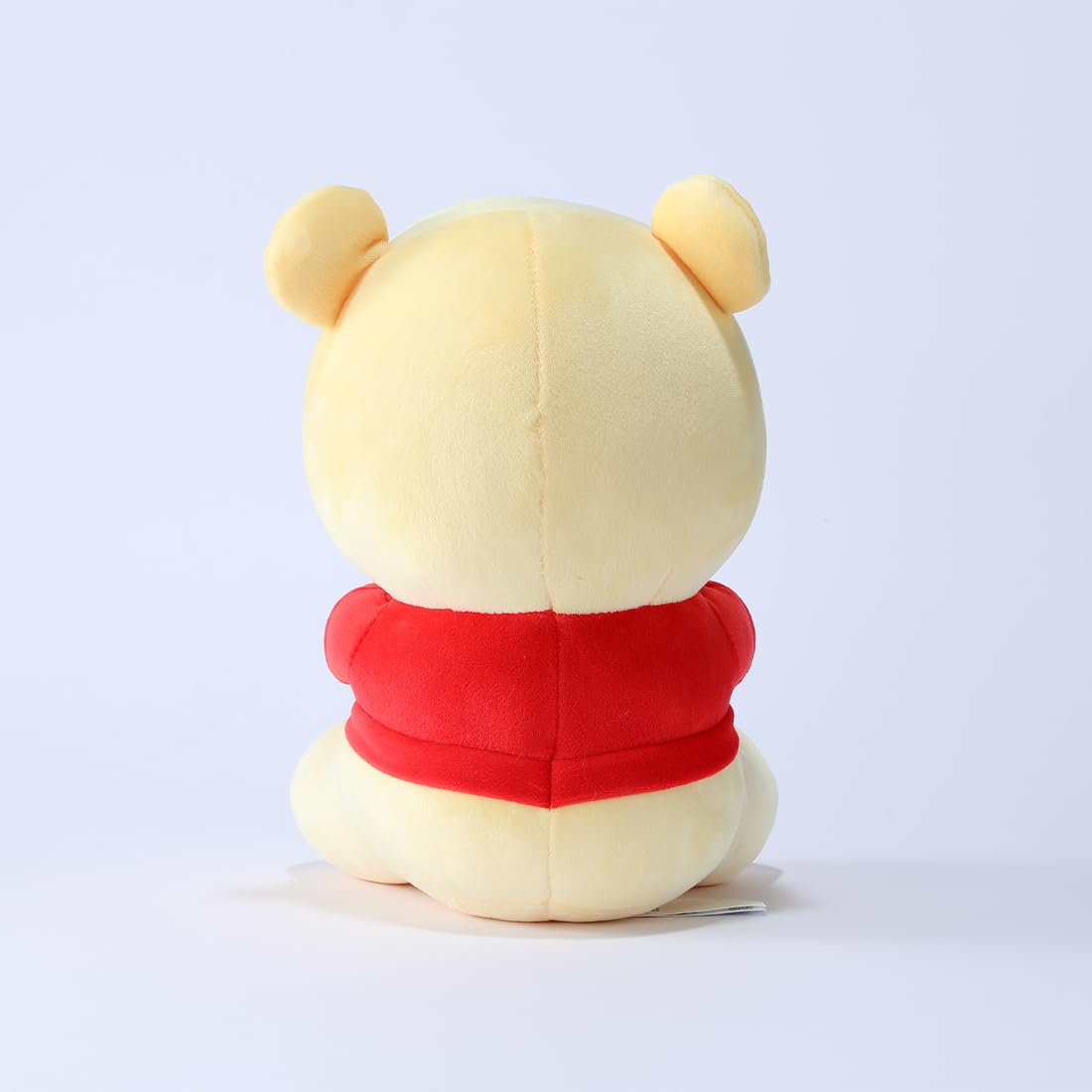 MINISO Winnie-the-Pooh plush holding biscuits provides a cute scene.