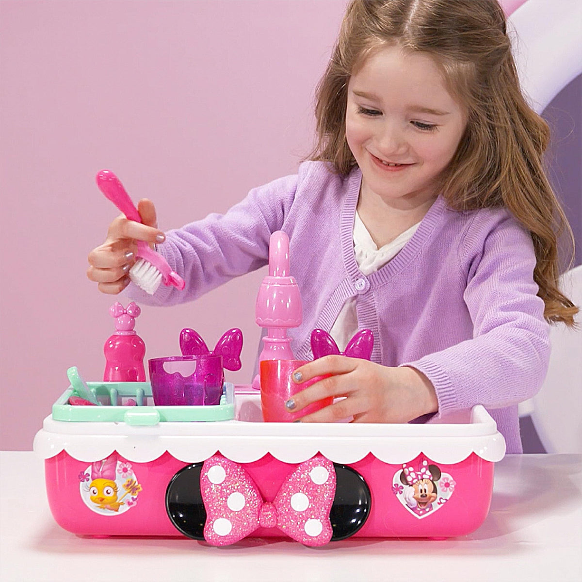 Bow-shaped handle pouring water from the pretend faucet on MINNIE sink