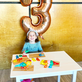 Child placing dinosaur pieces on a Montessori Mama puzzle board to improve focus.