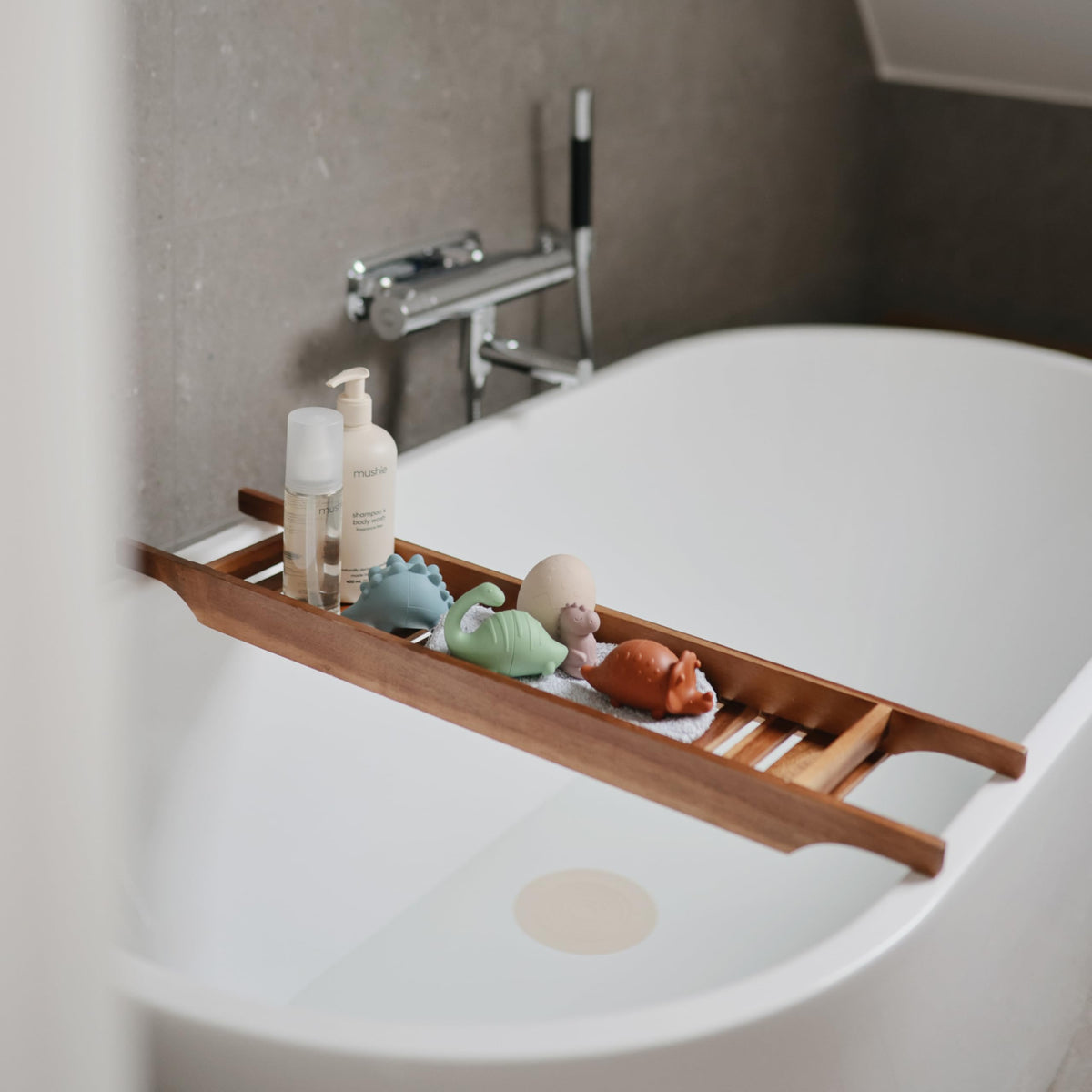 Mushie Dino bath toy soft silicone material for gentle grip.