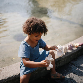 Mushie bath toy promotes fine motor skills through gentle spinning and pouring.