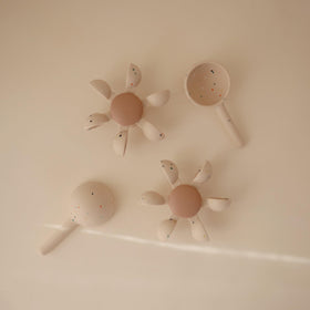 Mushie water wheel cups spin when water pours, revealing cause-and-effect play.