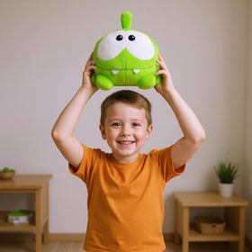 Om Nom plush toy displayed on a shelf, bright and cheerful decor.