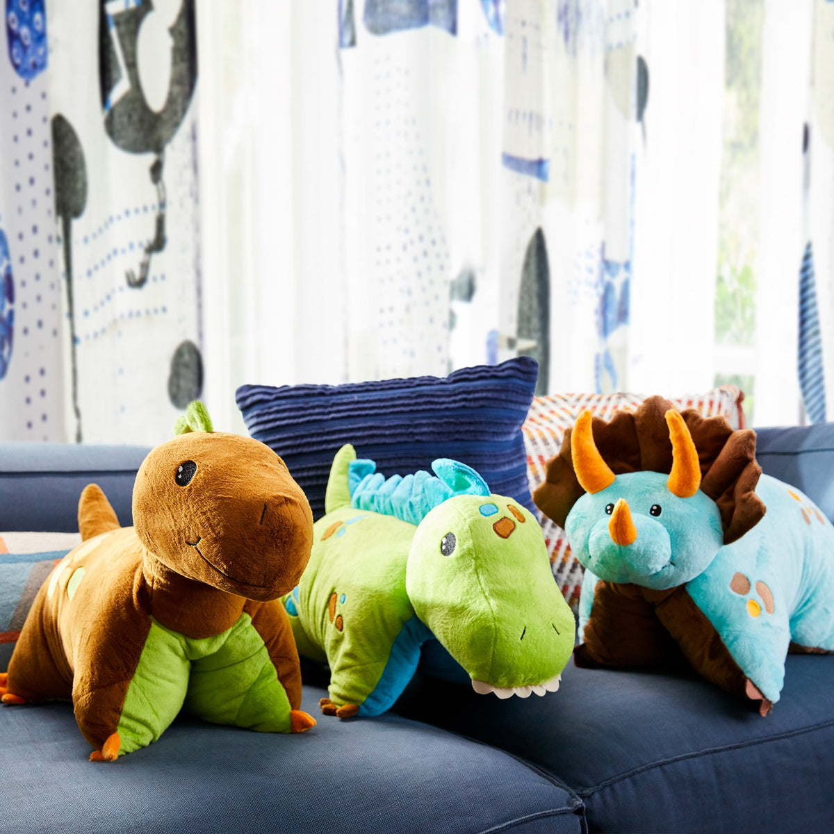 Pillow Pets blue dino rests softly on the bed for gentle support.