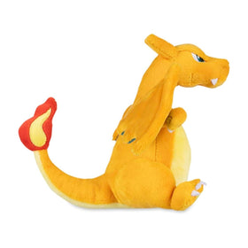 Pokémon Center Charizard Sitting Cuties plush on desk close-up, highlighting the microbead weighted base.