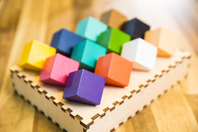 Chroma Cube tray with blocks neatly arranged in the laser-cut wooden tray.