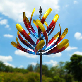Promised Farm large wind spinner towering in a garden with bold colors and movement.