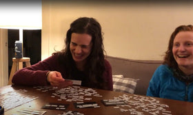 Ransom Notes players laughing around a table during game night.