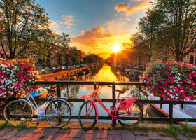 Ravensburger Bicycles in Amsterdam puzzle cover, vibrant sunset colors, perfect for cozy puzzling evenings.