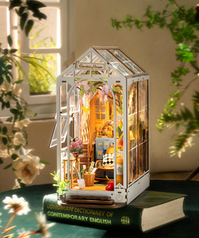 Robotime wooden puzzle pieces come together to form a complete garden house scene.