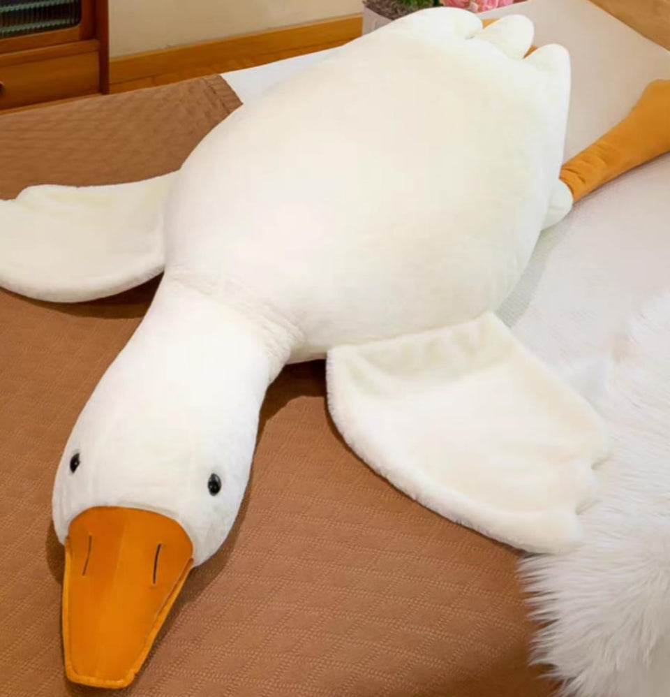 Ryttir giant goose plush on a bed, offering cozy comfort for movie nights.