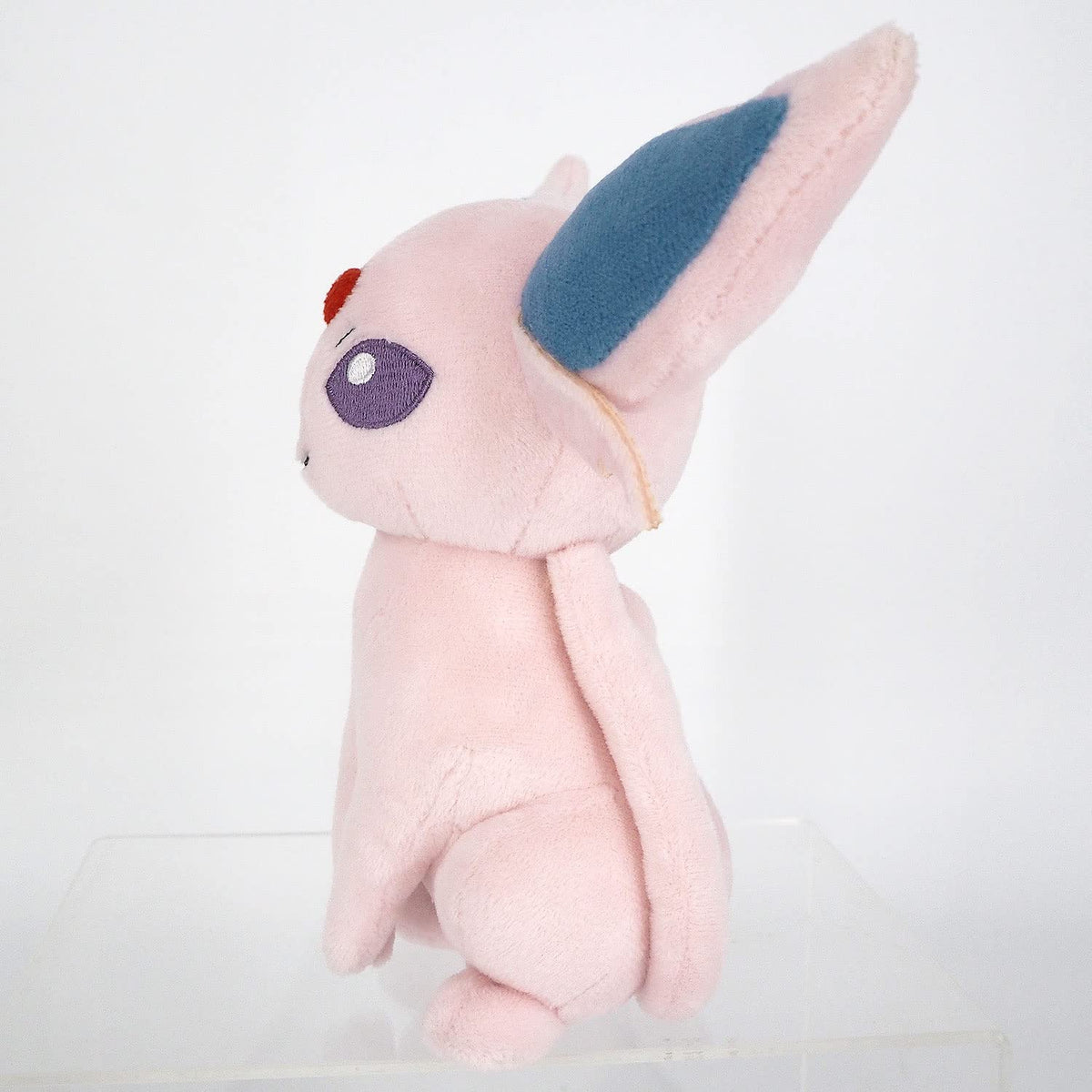 Espeon plush showing large ears and tiny paws for poseable display.