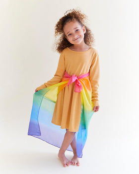 Sarah's Silks Rainbow playsilk folded, inviting tactile exploration.