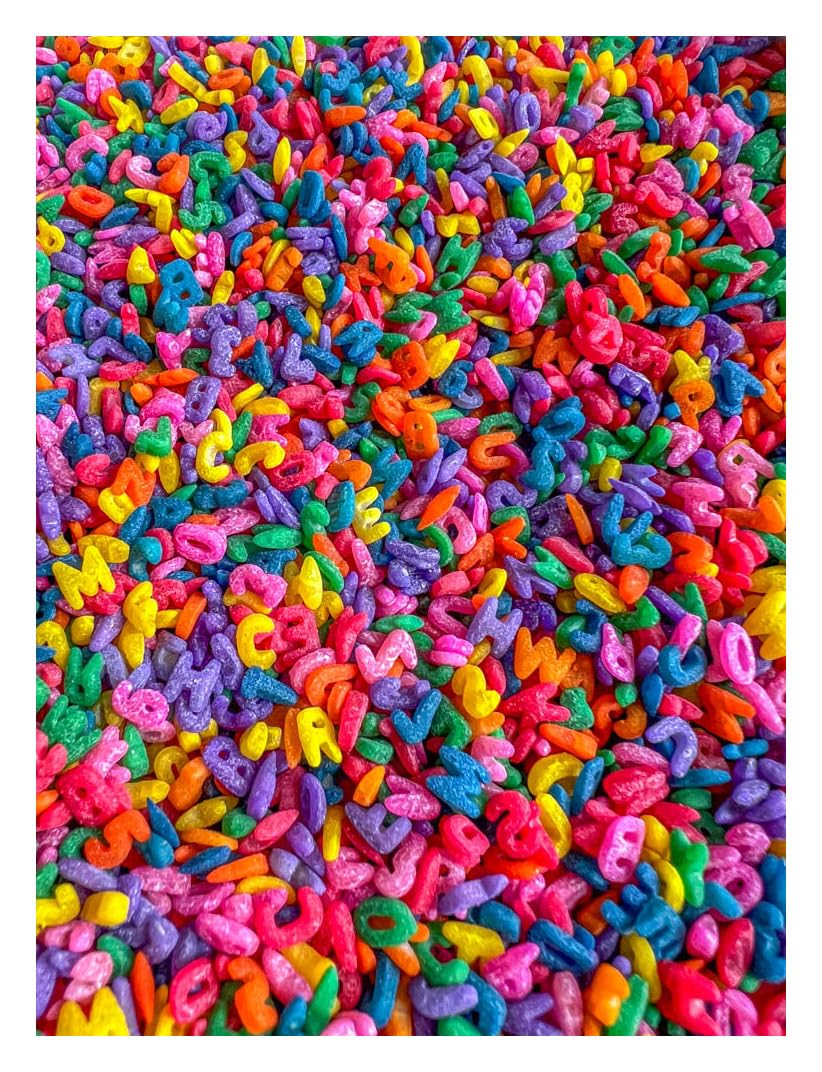 Sensory-N-Stuff rainbow alphabet pasta in a bin for tactile exploration and imaginative play.
