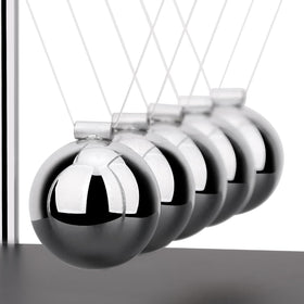 SEVNPRIME physics cradle used as an educational tool on a desk.