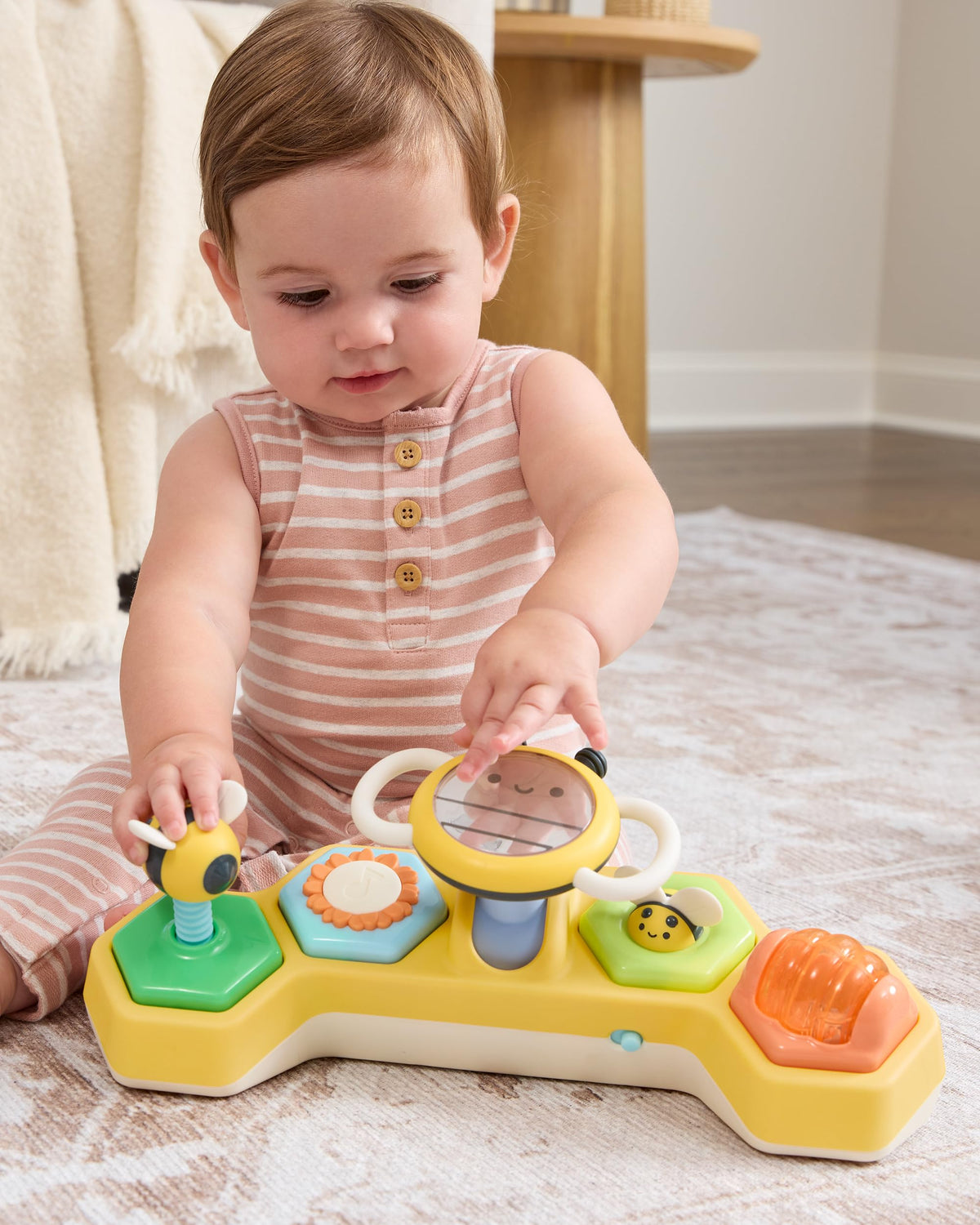 Skip Hop Farmstand See & Bee steering wheel in seated play encourages reaching and grasping.