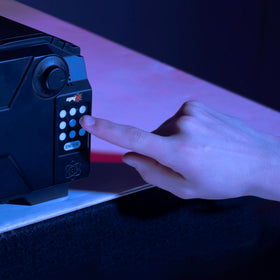 Kid demonstrates code entry on SpyX Alarm Safe, encouraging problem-solving.