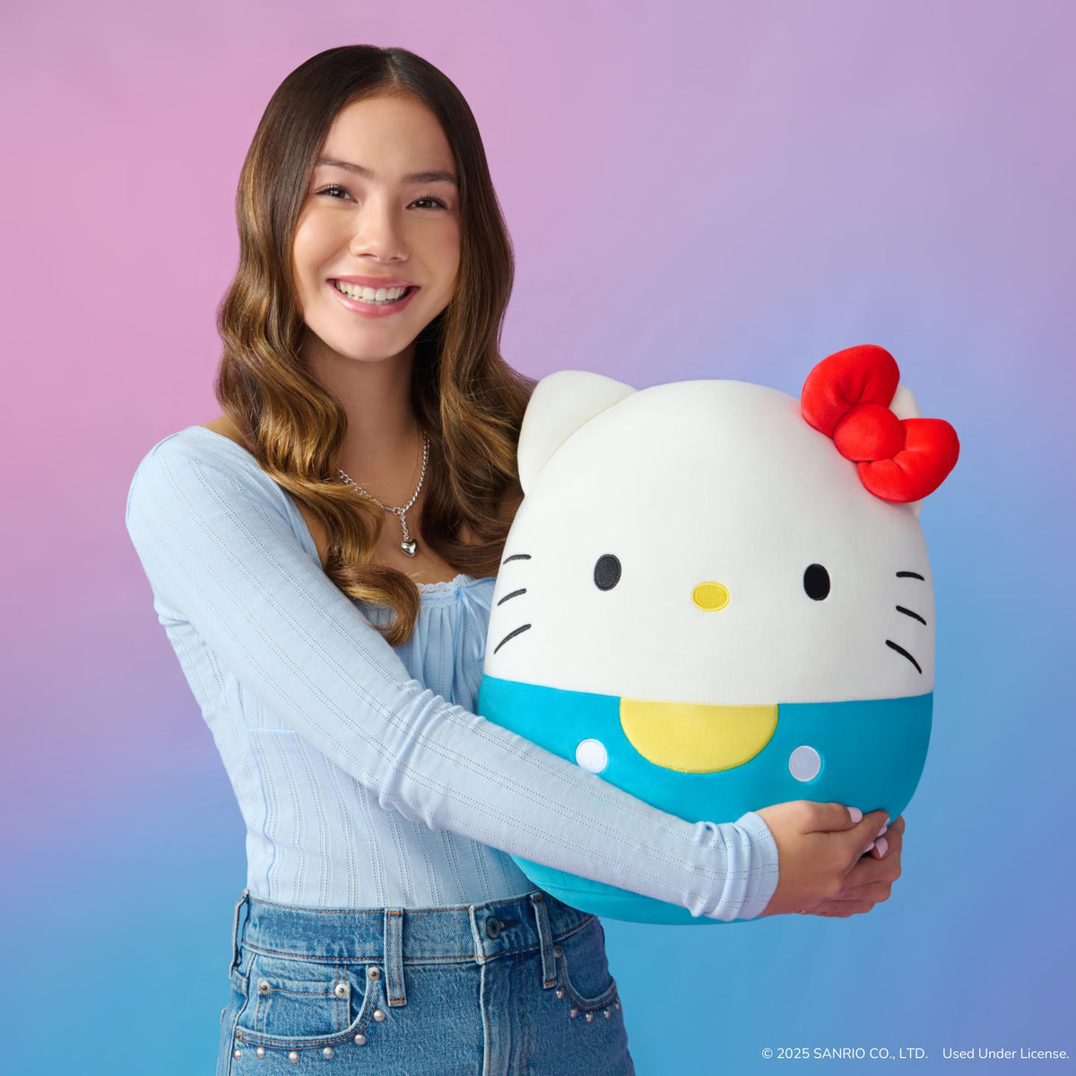 Close-up of Hello Kitty plush in blue overalls showing ultrasoft fabric.