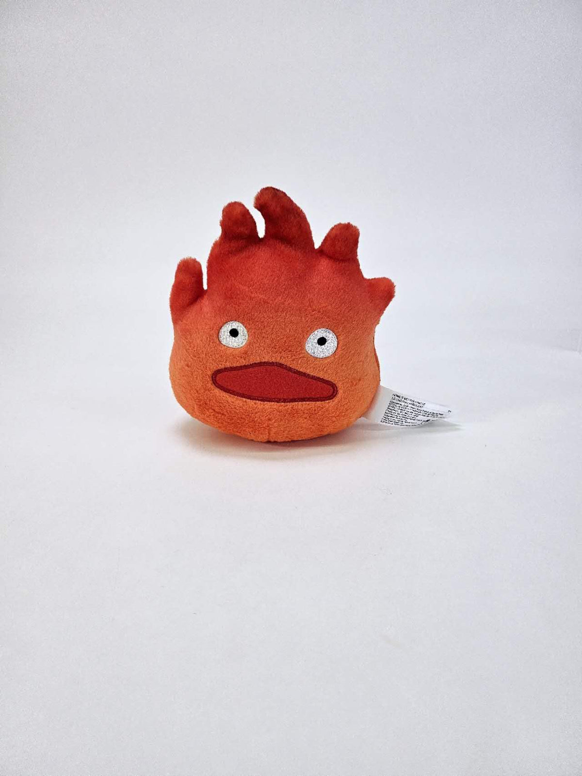 Calcifer plush on a decorative shelf, whimsical Studio Ghibli decor.