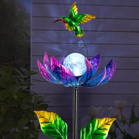 Sunnylight purple cracked-glass globe glows softly at night for ambient garden lighting.