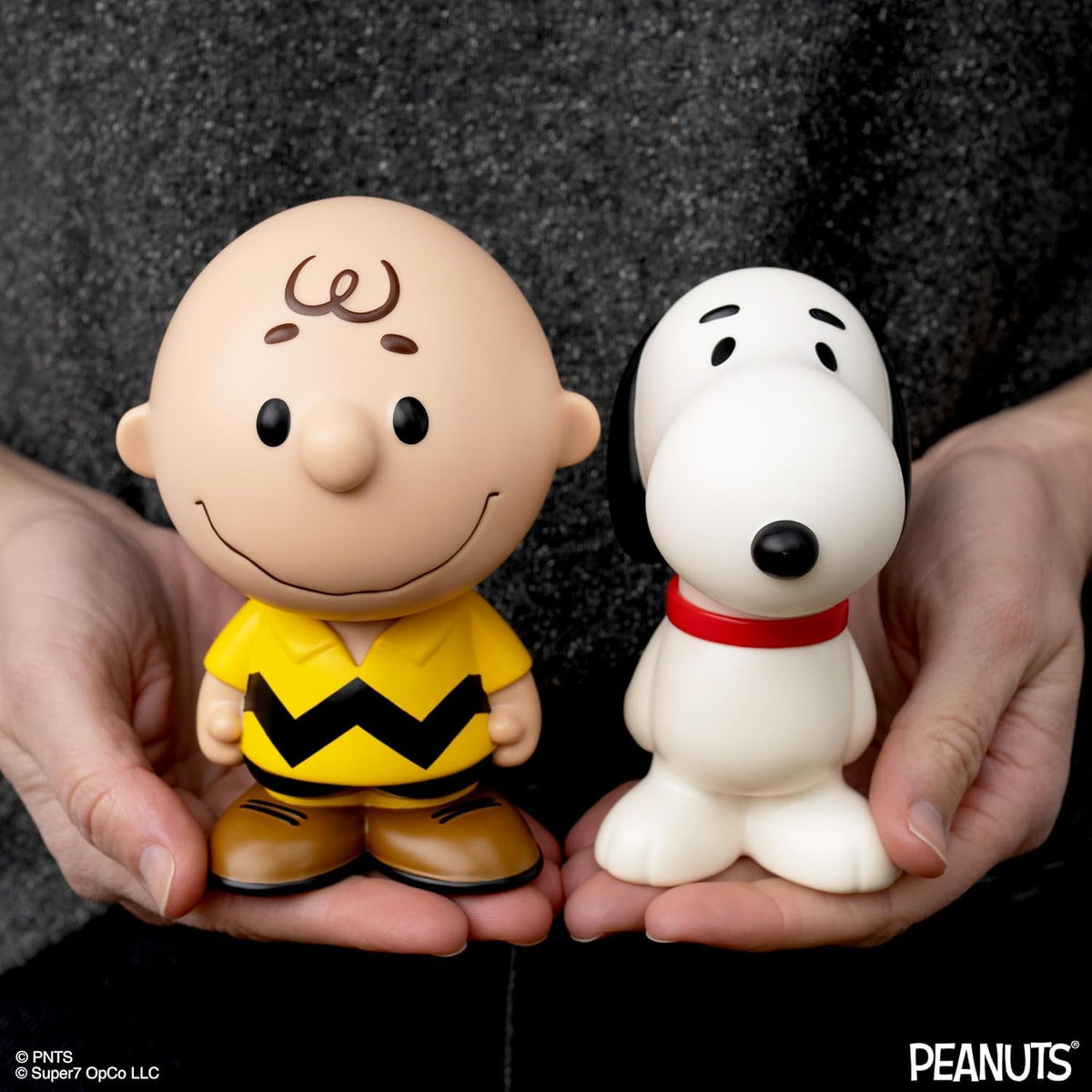 Super7 Charlie Brown yellow figure shown on a shelf with other Peanuts figures