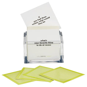 TableTopics cards inside a clear cube container on a dining table