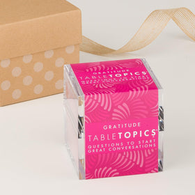 TableTopics Gratitude card set shown beside cozy seating for sharing memories.